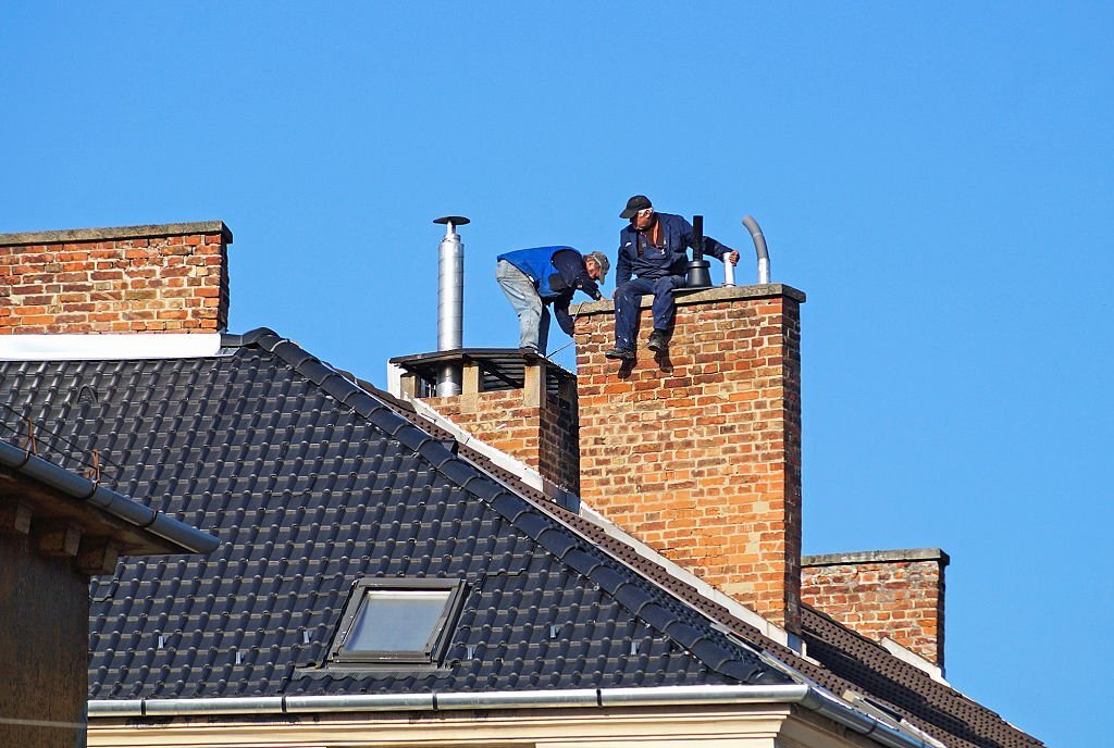 Chimney sweeps are working on the roof