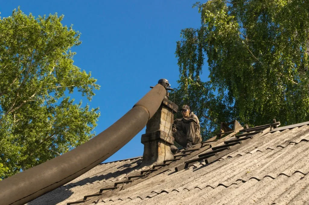 Sweep working at a rooftop flue